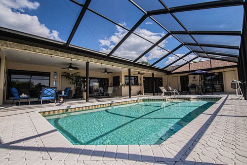 A screened lanai pool alongside a Fort Myers home